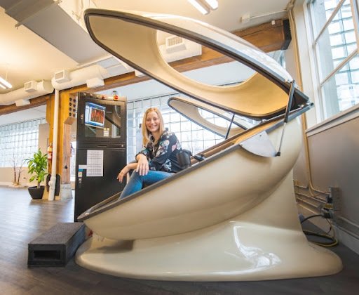 A CVAC Pod open in a wellness centre with a person seated inside before a session.