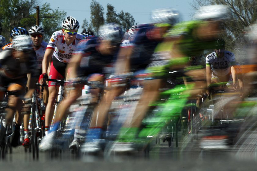 A tightly packed road race field sprinting past, captured with motion blur at the Tour de Murrieta.